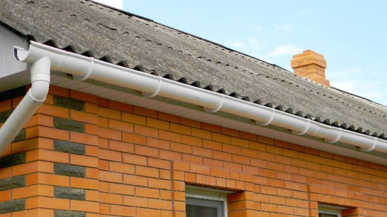 Brick bungalow with white fascias, gutters and a tiled roof